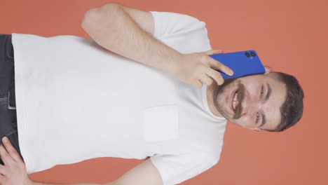 Vertical-video-of-Happy-talking-man-on-the-phone.